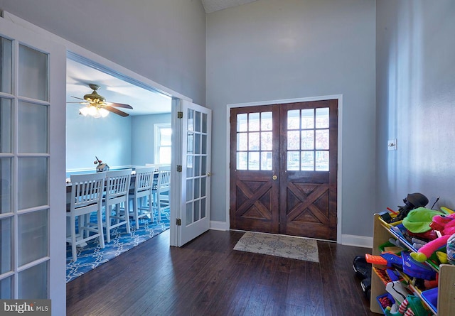 foyer with dark hardwood / wood-style floors, ceiling fan, and french doors