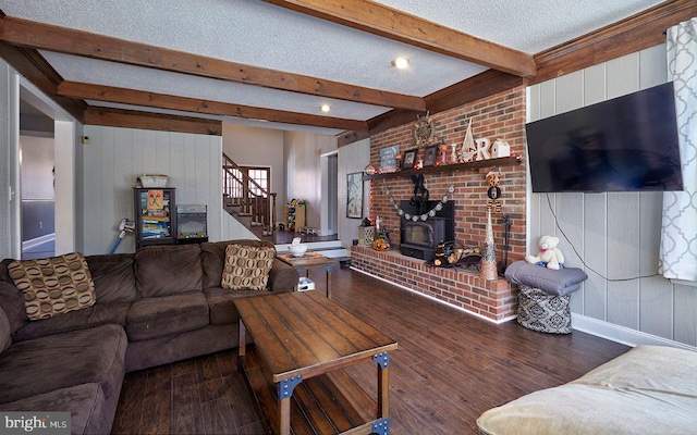 living room with a wood stove, hardwood / wood-style floors, beamed ceiling, and a textured ceiling