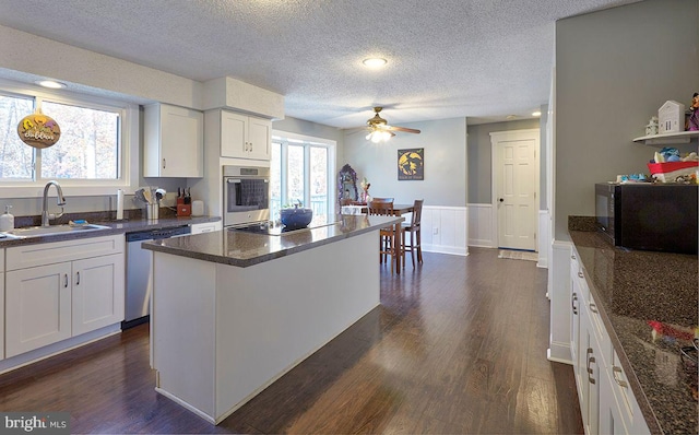 kitchen featuring a center island, sink, white cabinets, and appliances with stainless steel finishes