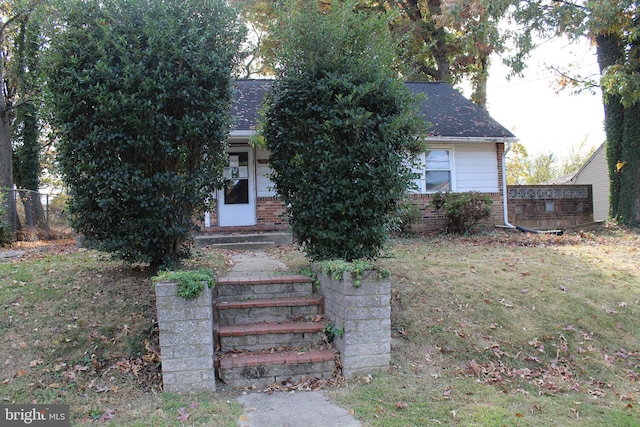 view of property hidden behind natural elements featuring a front yard