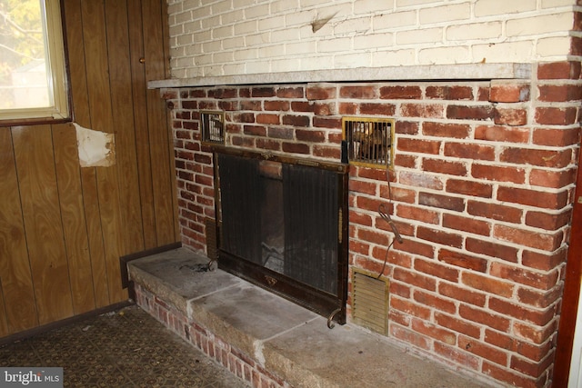 room details featuring a fireplace and wooden walls