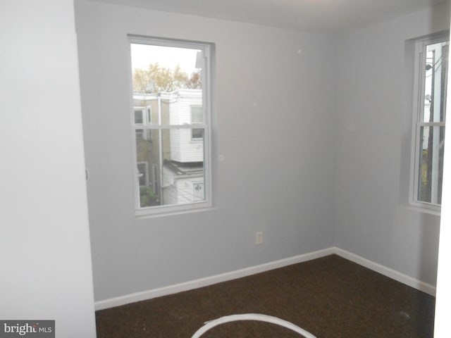 empty room with dark colored carpet