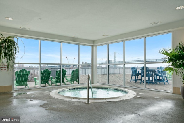 view of pool featuring a water view and an indoor hot tub