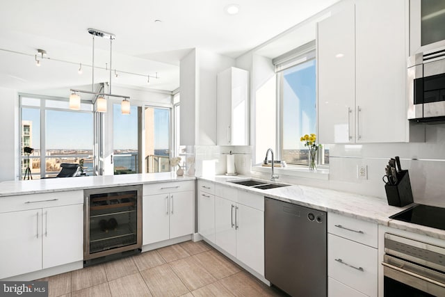 kitchen featuring white cabinetry, stainless steel appliances, wine cooler, plenty of natural light, and decorative light fixtures