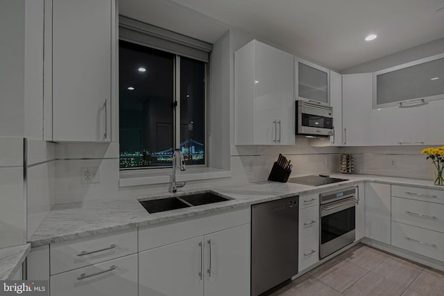 kitchen featuring light stone countertops, white cabinetry, sink, and appliances with stainless steel finishes