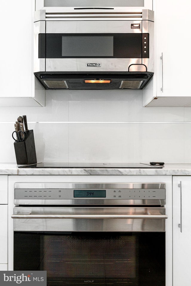 details featuring white cabinets and appliances with stainless steel finishes