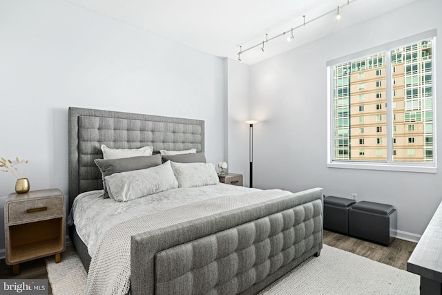 bedroom with wood-type flooring and track lighting