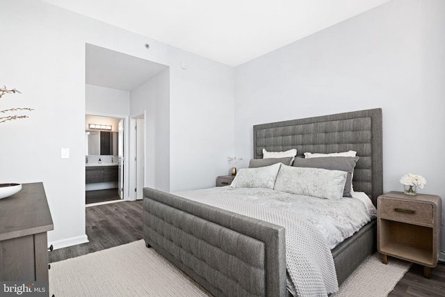 bedroom with ensuite bath and dark hardwood / wood-style flooring