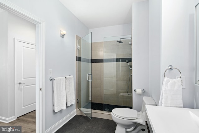 bathroom featuring hardwood / wood-style floors, vanity, toilet, and a shower with door