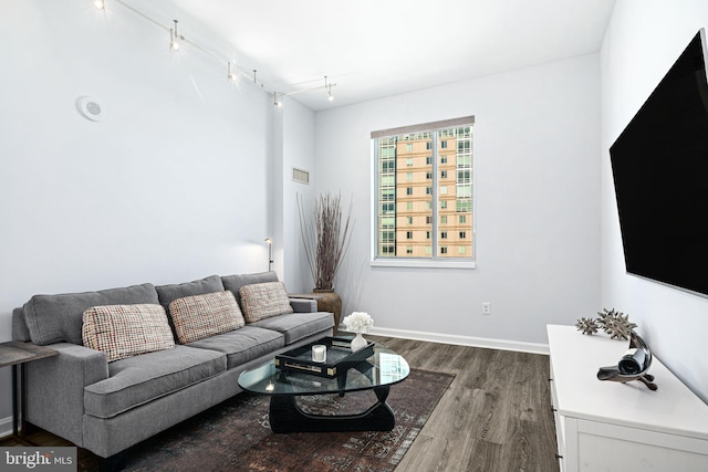 living room featuring dark hardwood / wood-style flooring and rail lighting