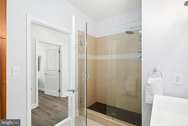 bathroom featuring hardwood / wood-style flooring and a shower with door