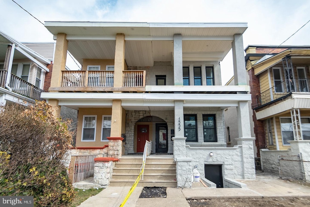 multi unit property featuring a porch and a balcony