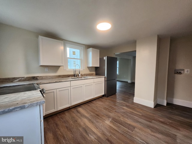 kitchen featuring stainless steel refrigerator, light stone countertops, sink, dark hardwood / wood-style floors, and white cabinets