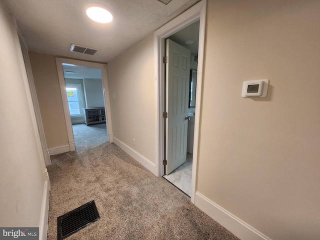 hallway featuring light colored carpet