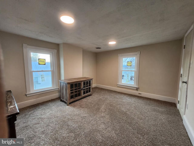 empty room with carpet flooring and a textured ceiling