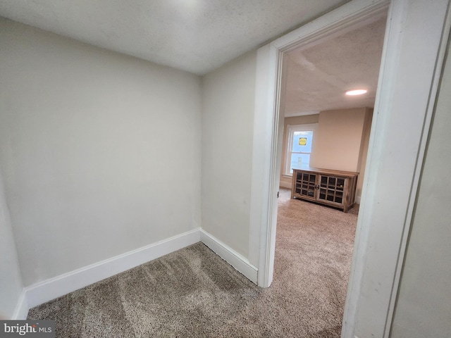 hall with carpet and a textured ceiling