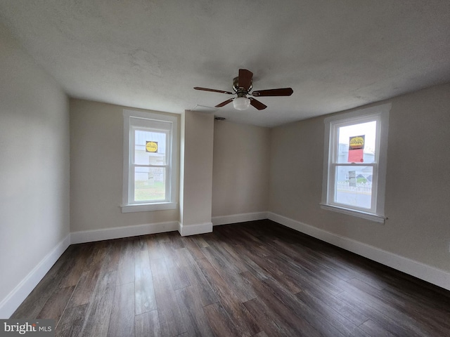 empty room with ceiling fan, dark hardwood / wood-style flooring, and a textured ceiling