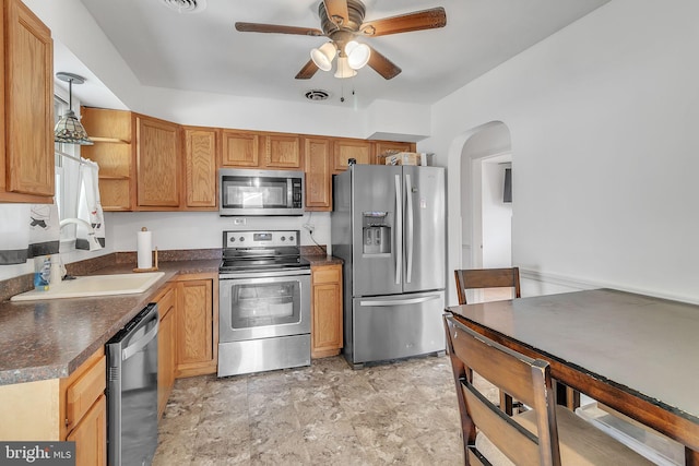 kitchen featuring appliances with stainless steel finishes, ceiling fan, pendant lighting, and sink