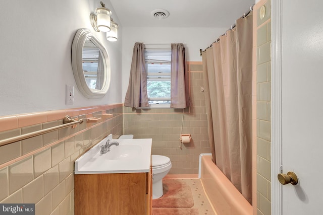 full bathroom with vanity, tile patterned floors, toilet, tile walls, and shower / tub combo with curtain