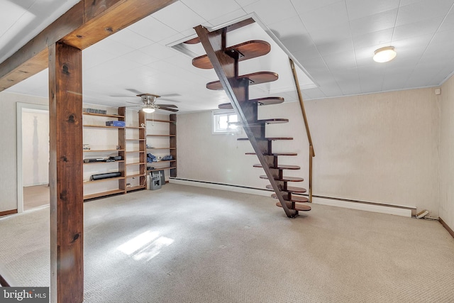 basement featuring carpet, ceiling fan, and a baseboard heating unit