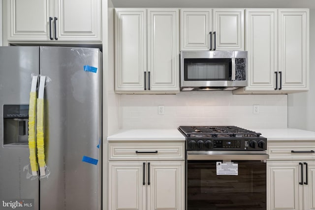 3013 Wharton St, Philadelphia, PA 19146 - kitchen with appliances with stainless steel finishes, light countertops, tasteful backsplash, and white cabinets