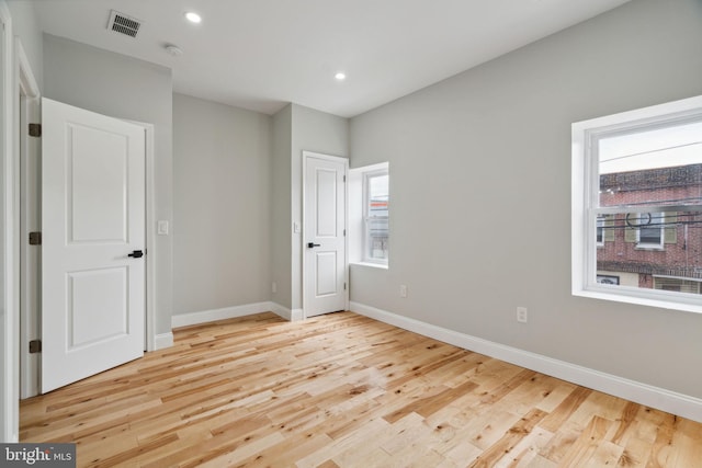 unfurnished bedroom featuring light hardwood / wood-style floors and multiple windows