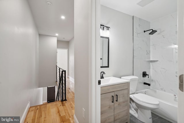 full bathroom featuring tiled shower / bath, toilet, vanity, and hardwood / wood-style flooring