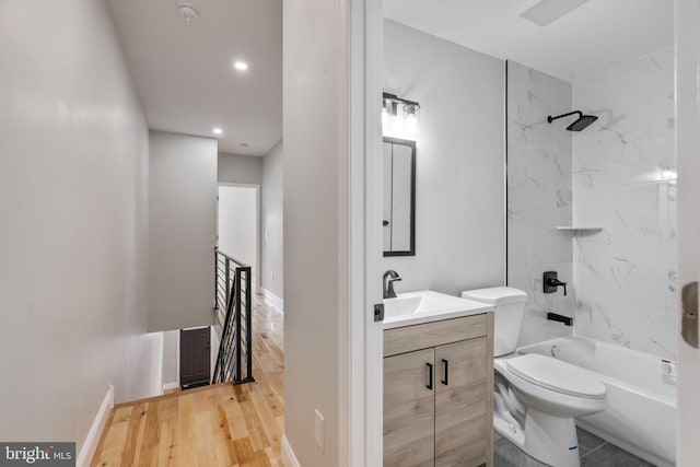 full bathroom featuring vanity, hardwood / wood-style flooring, toilet, and tiled shower / bath