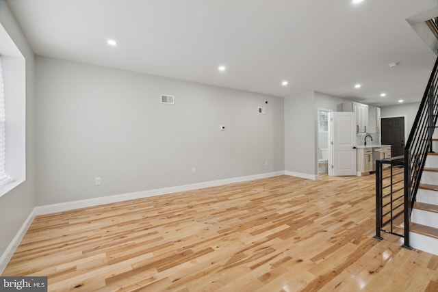 3013 Wharton St, Philadelphia, PA 19146 - unfurnished living room with stairway, light wood-type flooring, baseboards, and recessed lighting