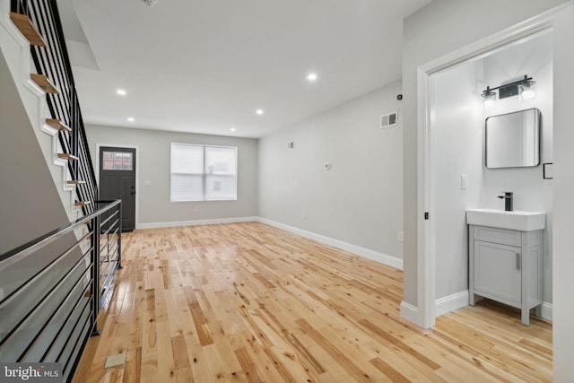 3013 Wharton St, Philadelphia, PA 19146 - unfurnished living room featuring a sink, light wood finished floors, baseboards, stairway, and recessed lighting