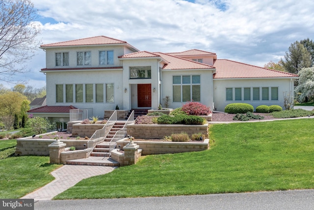 mediterranean / spanish house featuring a front yard