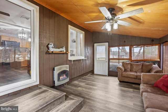 living room with a wood stove, heating unit, vaulted ceiling, wood ceiling, and hardwood / wood-style flooring