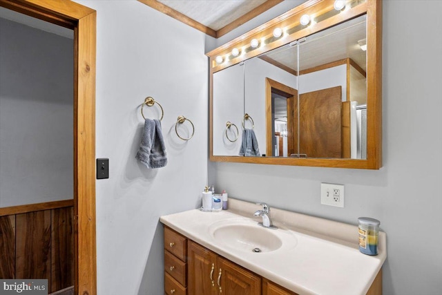 bathroom featuring vanity, wood walls, and ornamental molding