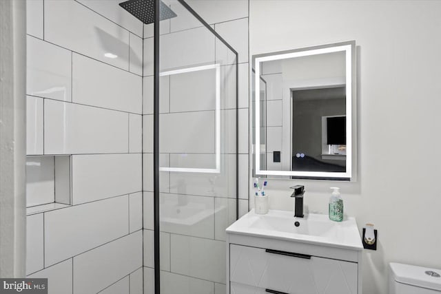 bathroom featuring tiled shower, vanity, and toilet