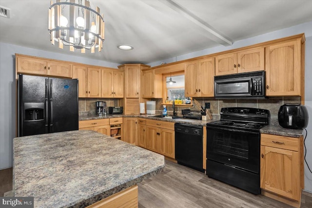 kitchen featuring decorative backsplash, hardwood / wood-style floors, a notable chandelier, and black appliances