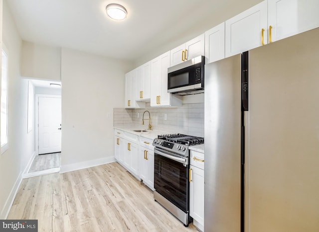 kitchen featuring white cabinets, stainless steel appliances, light hardwood / wood-style floors, and sink