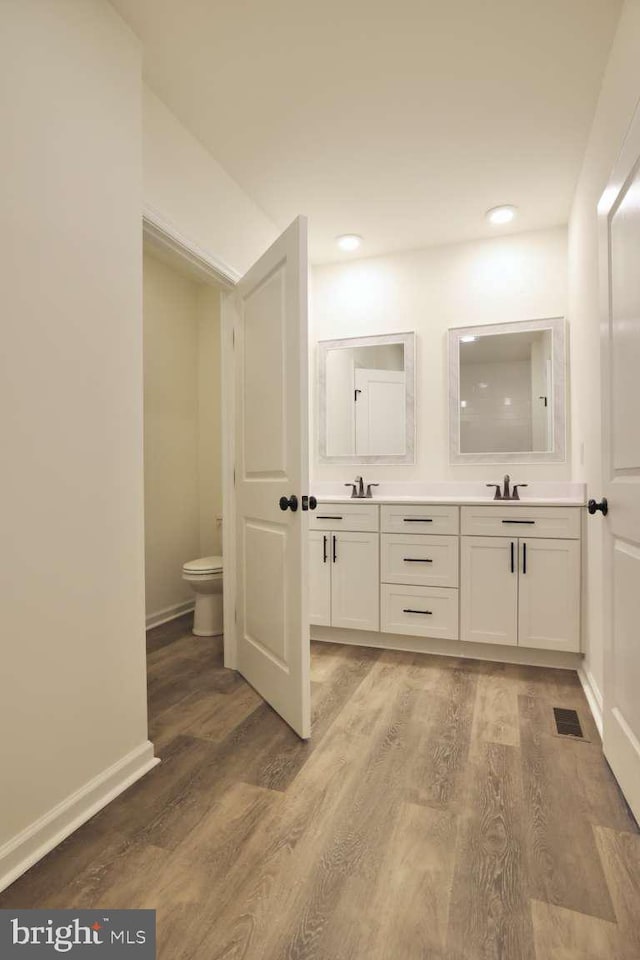 bathroom featuring hardwood / wood-style flooring, vanity, and toilet