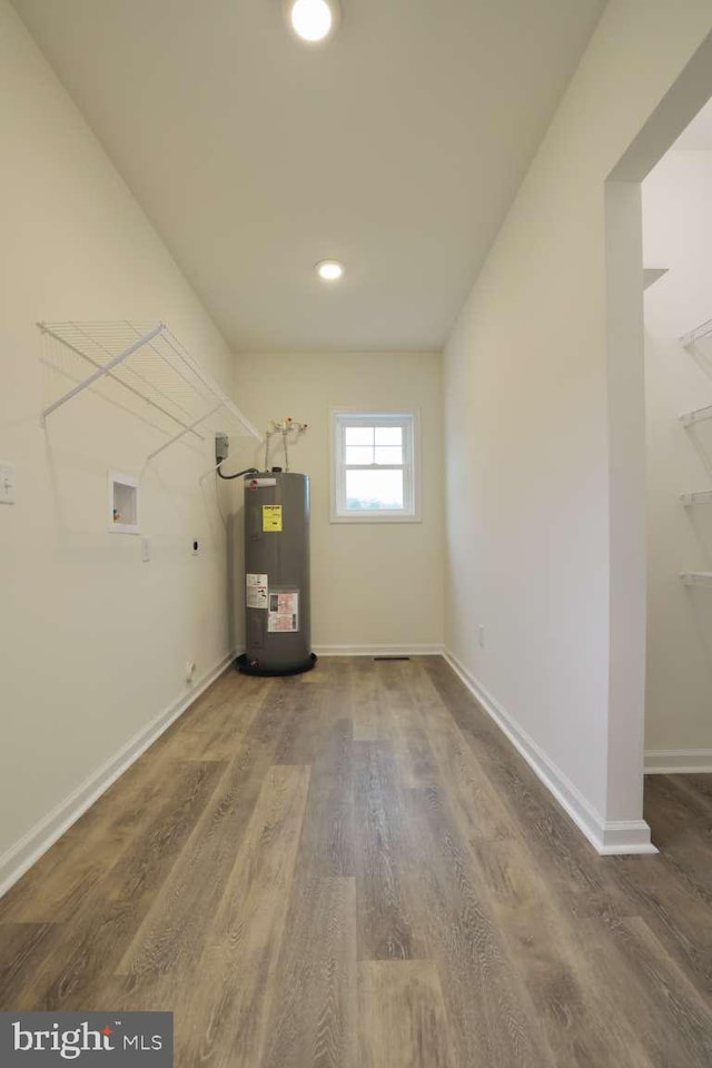 clothes washing area with washer hookup, dark hardwood / wood-style flooring, and water heater