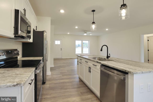 kitchen featuring white cabinets, decorative light fixtures, sink, and stainless steel appliances