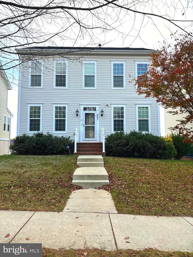 colonial inspired home featuring a front lawn