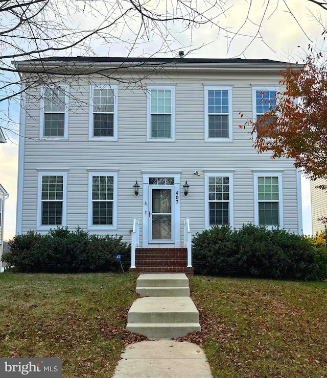 colonial inspired home featuring a yard