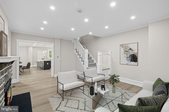 living room featuring light wood-type flooring and crown molding