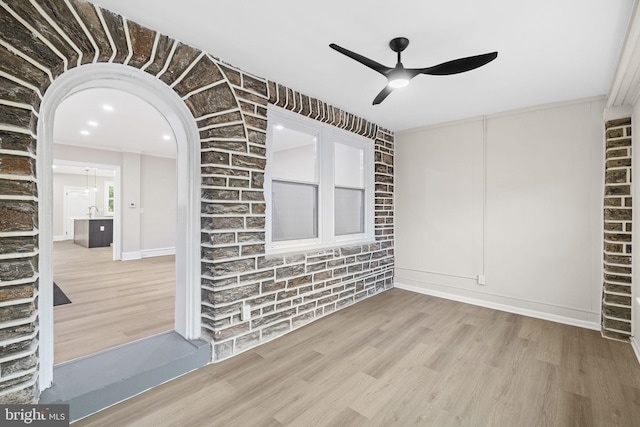 unfurnished room featuring ceiling fan, wood-type flooring, and ornamental molding