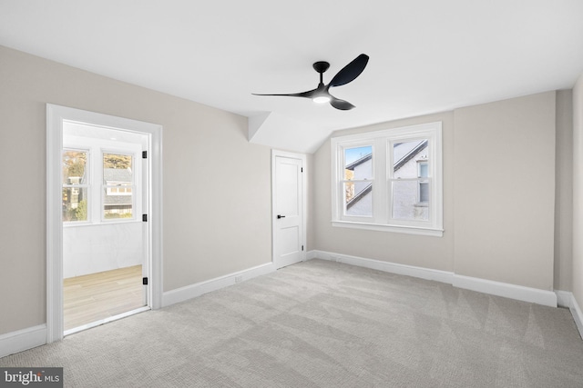 bonus room with ceiling fan and light carpet