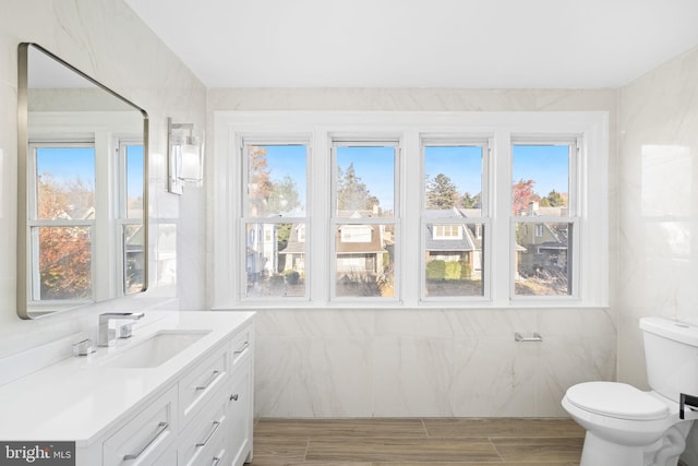 bathroom featuring a healthy amount of sunlight and tile walls