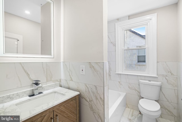 bathroom featuring vanity, toilet, and tile walls