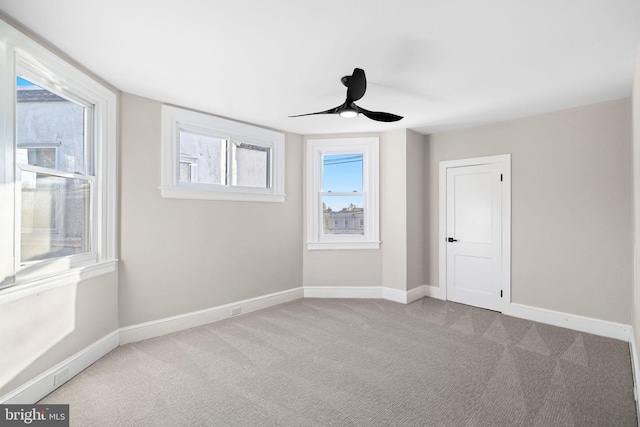 carpeted spare room featuring ceiling fan