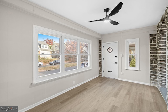 interior space with ceiling fan, crown molding, and light hardwood / wood-style flooring