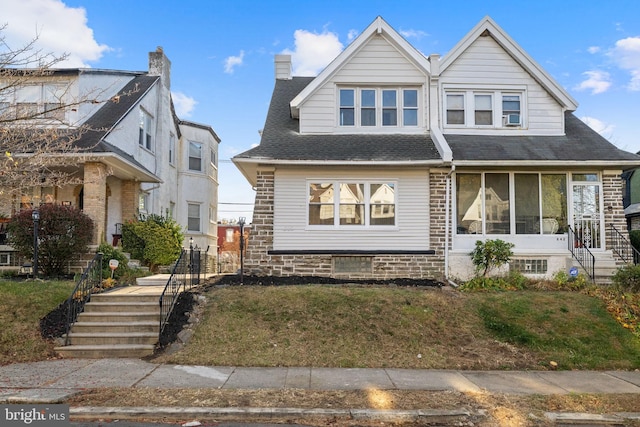 view of front of home with a front lawn and a sunroom