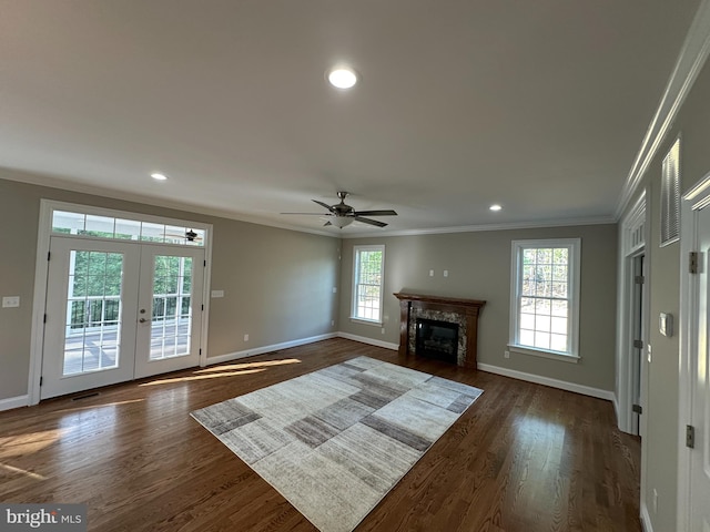 unfurnished living room with a wealth of natural light, ceiling fan, dark hardwood / wood-style floors, and ornamental molding